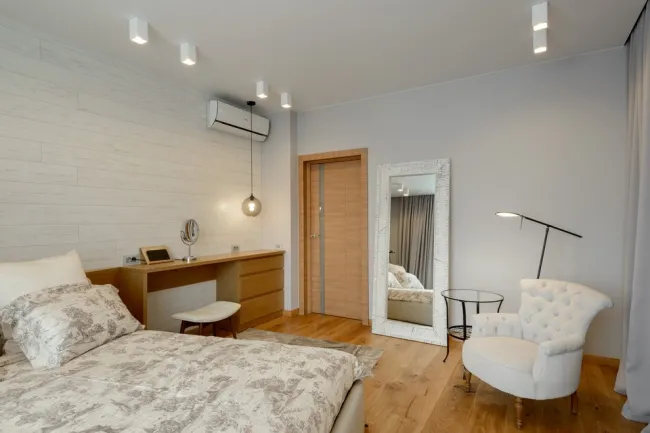 Белый ламинат на одной стене хорошо смотрится со светло-коричневым ламинатом на полу в спальне