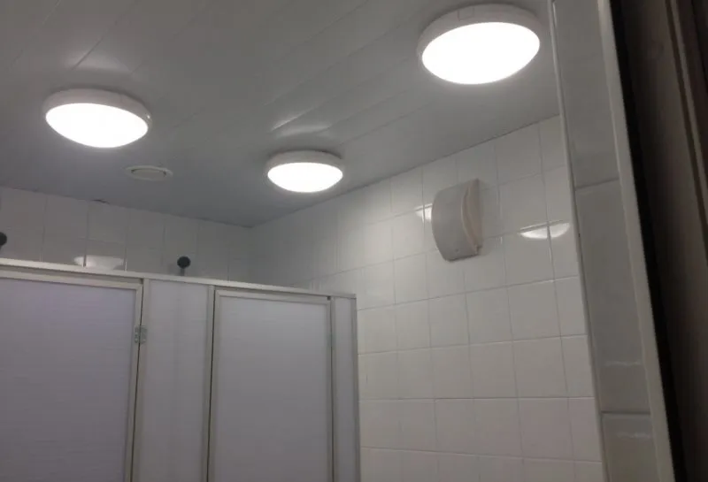 Три светильника накладного типа на потолке из ПВХ-панелей