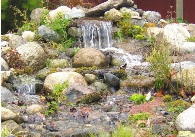 Водопад с обилием камней и растений выглядит совсем как настоящий