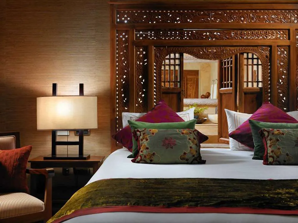 Много разноцветных подушек - фишка интерьера спальни в этническом стиле 