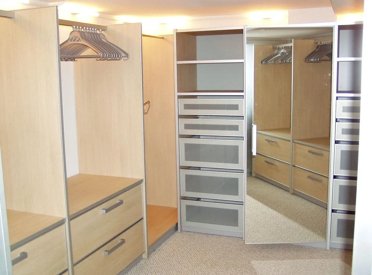 Маленькая гардеробная комната должна быть оснащена отделом для верхней одежды, выдвижными ящиками и полками 